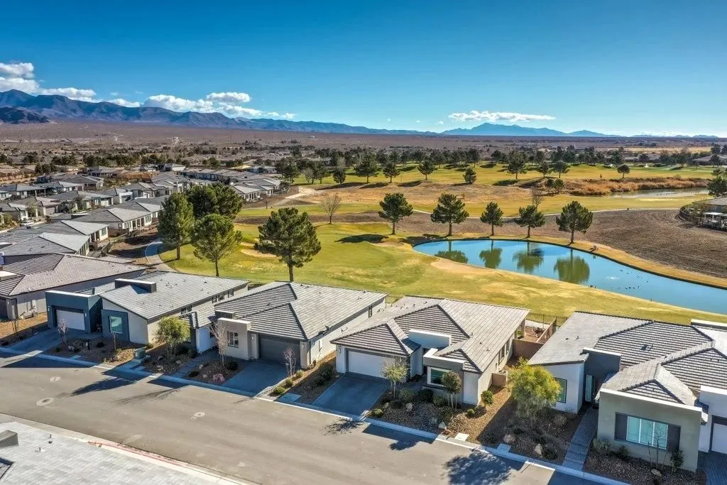Aerial view of single-storey homes along a golf course pond