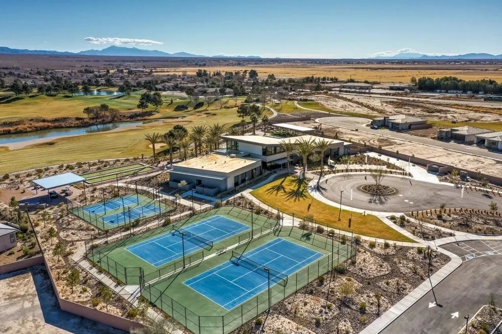 Aerial view of a clubhouse and courts, with the valley stretching east
