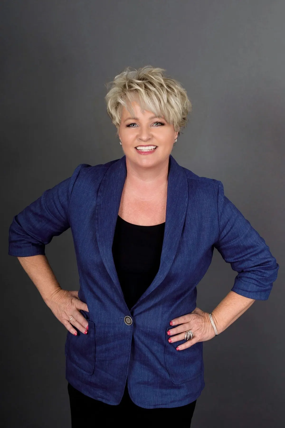 Marci Metzger in a blue blazer, smiling, hands on hips
