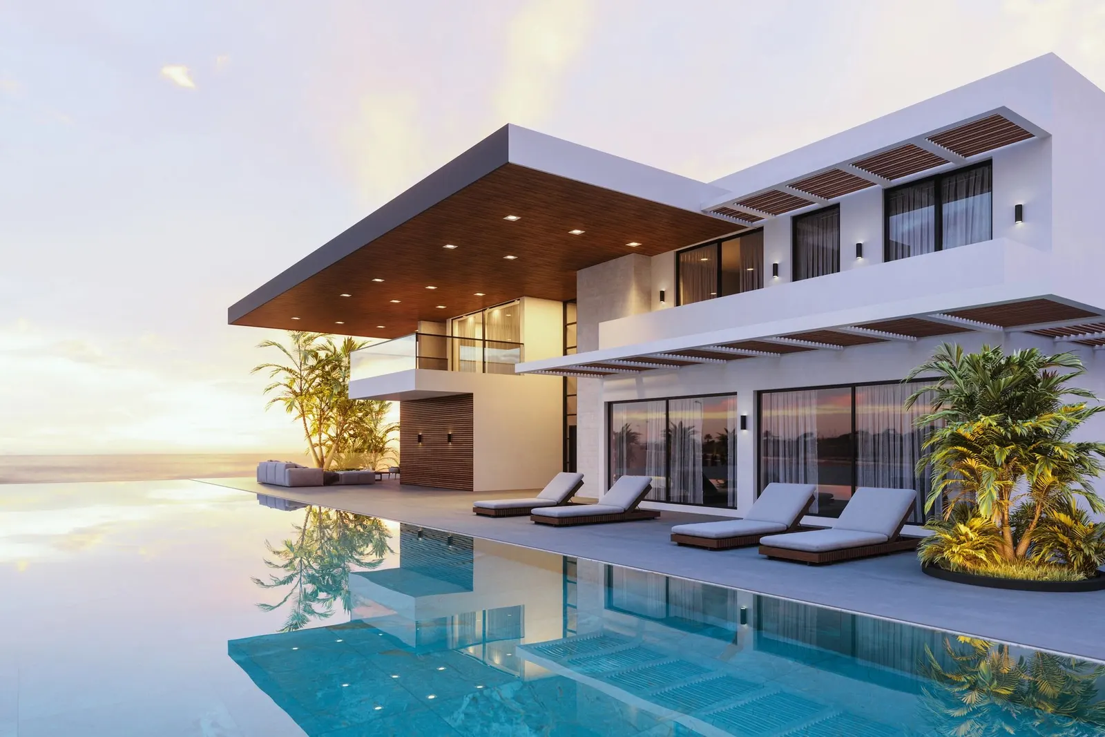 A white modern house with a long pool and loungers at sunset